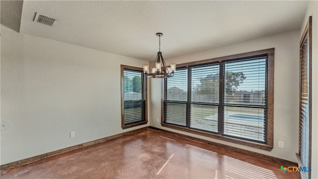 unfurnished dining area with plenty of natural light, a textured ceiling, and a notable chandelier