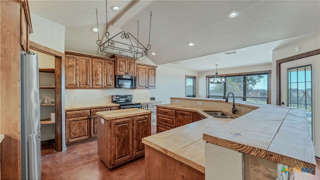 kitchen with sink, appliances with stainless steel finishes, an inviting chandelier, decorative light fixtures, and an island with sink