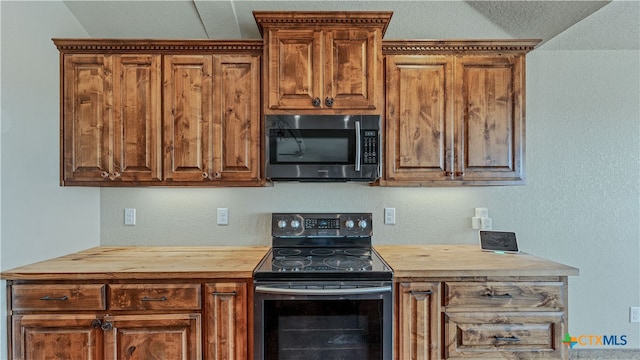 kitchen featuring black / electric stove, butcher block countertops, and vaulted ceiling