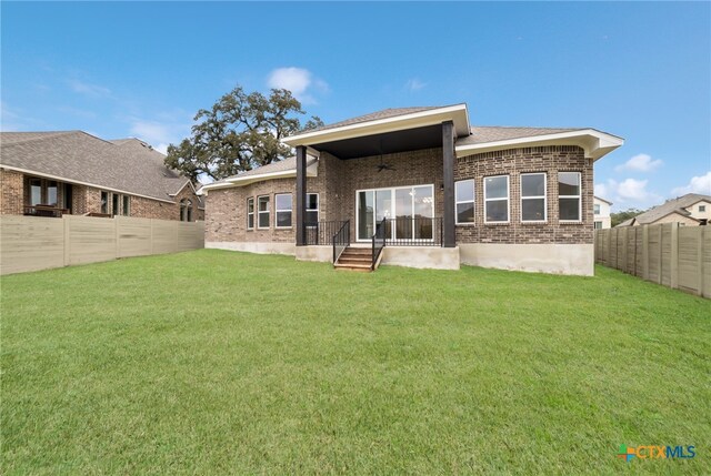 rear view of property featuring a yard