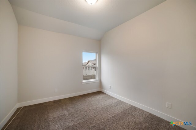 empty room with lofted ceiling and carpet floors