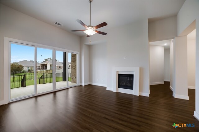 unfurnished living room featuring dark wood-type flooring and ceiling fan