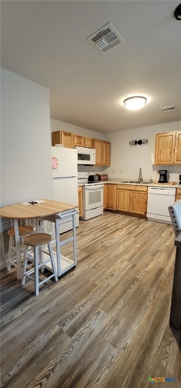 502 S 9th St, Seadrift, TX 77983 - kitchen featuring light wood-style floors, white appliances, visible vents, light countertops, and a sink