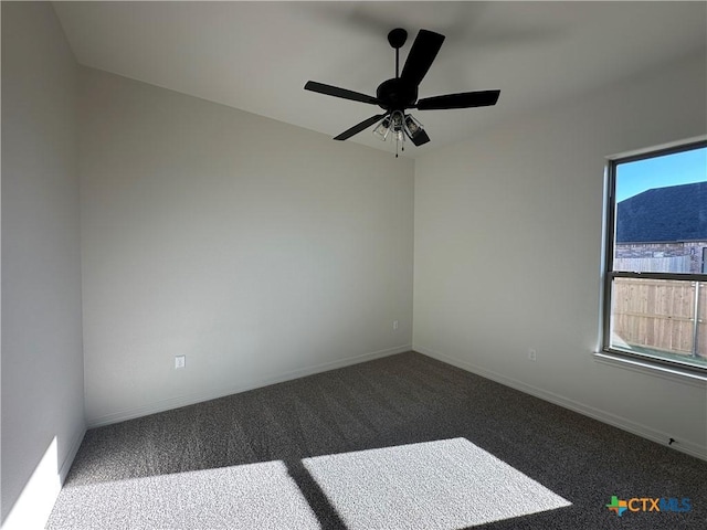 spare room with ceiling fan and dark colored carpet