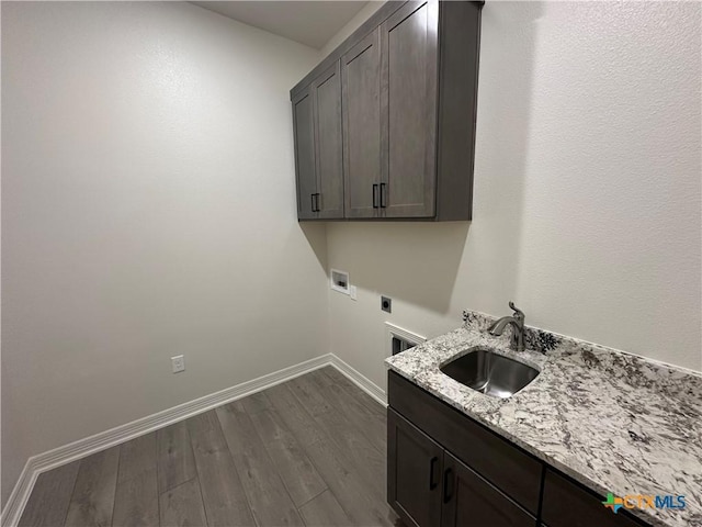 washroom featuring sink, dark hardwood / wood-style flooring, cabinets, and electric dryer hookup