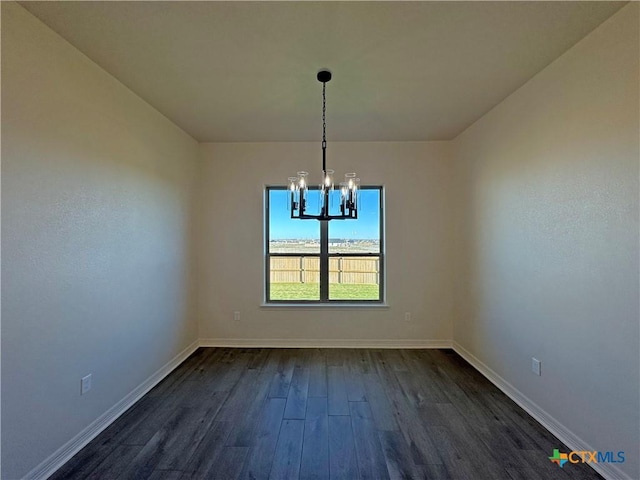 unfurnished dining area featuring a chandelier and dark hardwood / wood-style floors