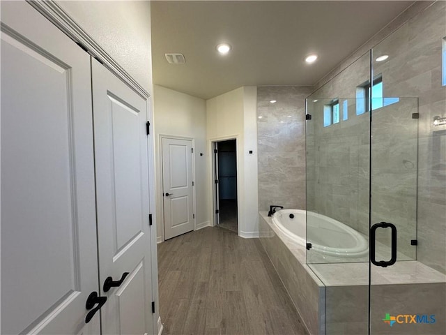 bathroom with hardwood / wood-style floors and shower with separate bathtub