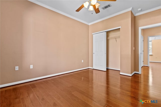 unfurnished bedroom featuring ornamental molding, hardwood / wood-style flooring, ceiling fan, and a closet