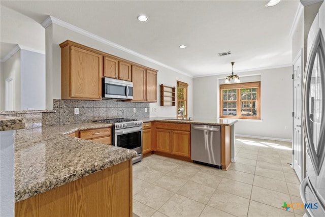 kitchen featuring kitchen peninsula, decorative light fixtures, appliances with stainless steel finishes, and ornamental molding