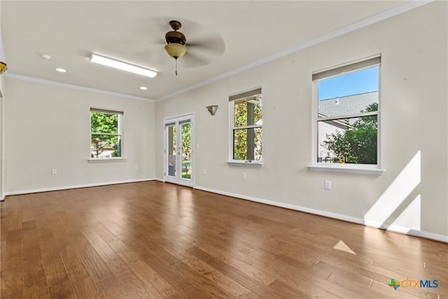 empty room featuring ornamental molding, wood-type flooring, and ceiling fan