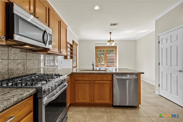 kitchen with light tile patterned flooring, ornamental molding, stainless steel appliances, sink, and kitchen peninsula