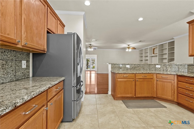 kitchen with ornamental molding, light stone countertops, ceiling fan, stainless steel refrigerator with ice dispenser, and light tile patterned floors