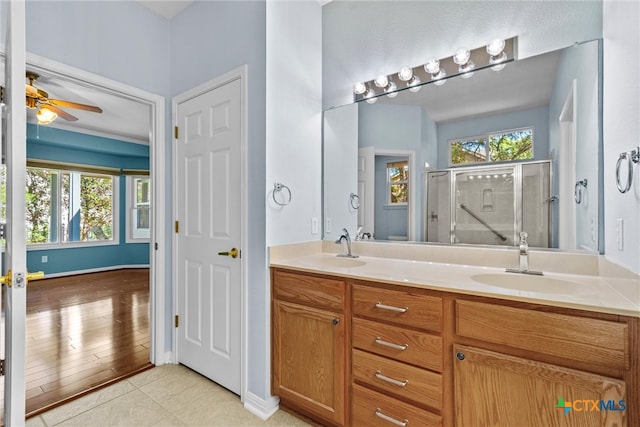 bathroom with an enclosed shower, vanity, hardwood / wood-style flooring, and ceiling fan