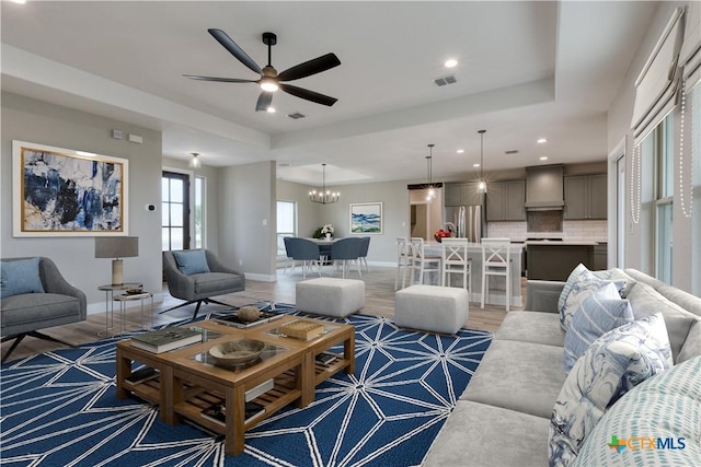 109 Wild Persimmon Trl, Marion, TX 78124 - living area with light wood-style flooring, recessed lighting, a chandelier, ceiling fan, and a tray ceiling