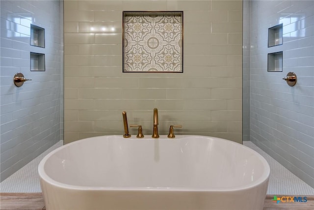 109 Wild Persimmon Trl, Marion, TX 78124 - bathroom featuring a freestanding bath, a walk in shower, and wood finished floors