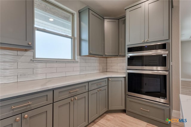 109 Wild Persimmon Trl, Marion, TX 78124 - kitchen featuring gray cabinets, stainless steel double oven, and decorative backsplash