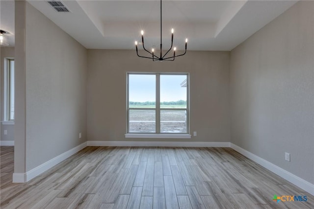 109 Wild Persimmon Trl, Marion, TX 78124 - unfurnished room featuring a tray ceiling, light wood-style floors, and a chandelier