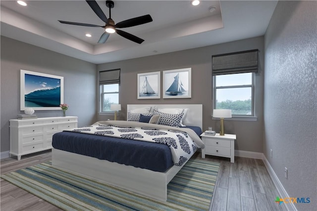 109 Wild Persimmon Trl, Marion, TX 78124 - bedroom with a raised ceiling, wood finished floors, multiple windows, recessed lighting, and ceiling fan