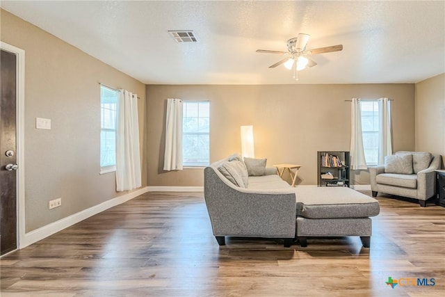 living room featuring hardwood / wood-style flooring, plenty of natural light, a textured ceiling, and ceiling fan