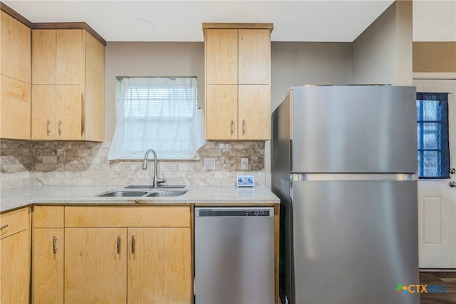 kitchen with appliances with stainless steel finishes, sink, and light brown cabinets