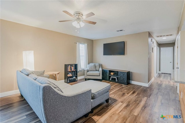 living room featuring hardwood / wood-style flooring and ceiling fan