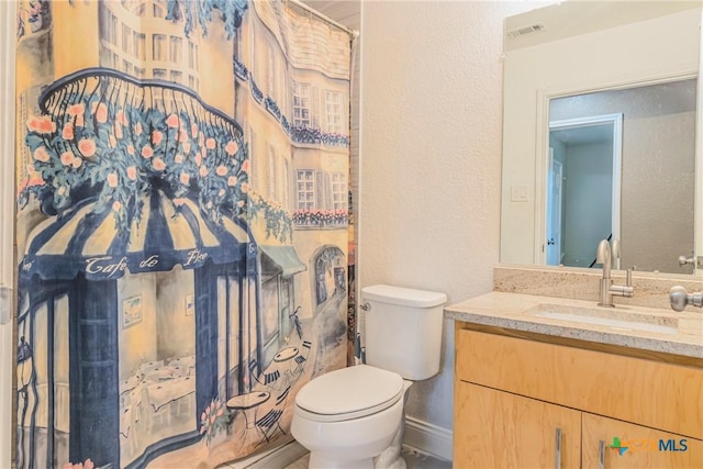 bathroom featuring vanity and toilet