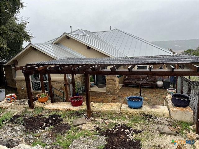 view of front of house with stone siding, a standing seam roof, and metal roof