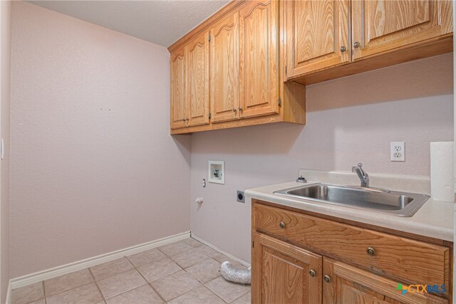 clothes washing area featuring hookup for an electric dryer, washer hookup, light tile patterned floors, cabinets, and sink