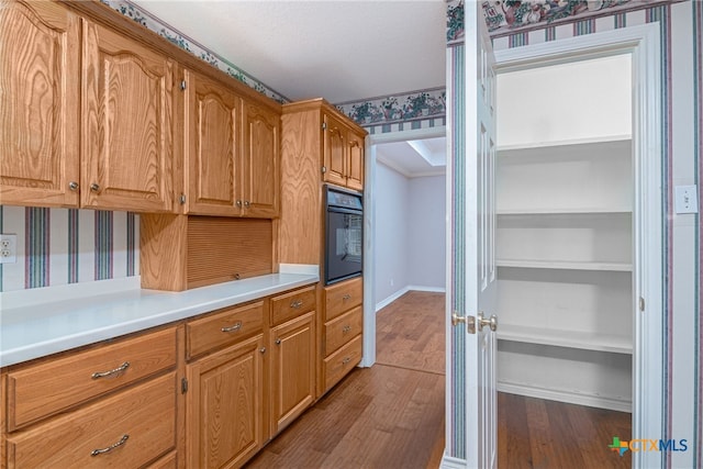 kitchen with black oven and light wood-type flooring