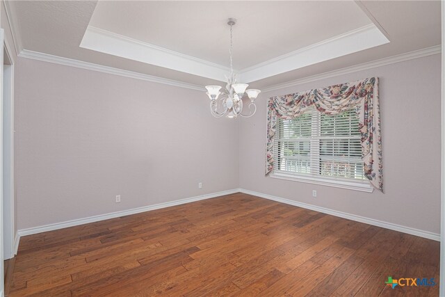 unfurnished room featuring ornamental molding, dark hardwood / wood-style floors, and a tray ceiling