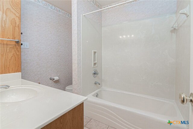 full bathroom with toilet, tub / shower combination, sink, and tile patterned flooring