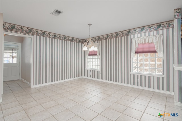 unfurnished dining area with a chandelier and light tile patterned floors