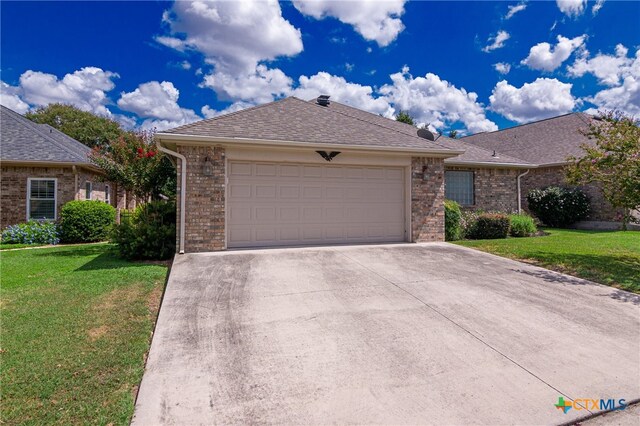 view of front of property featuring a garage and a front lawn