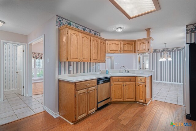 kitchen with dishwasher, kitchen peninsula, hanging light fixtures, light wood-type flooring, and stainless steel fridge