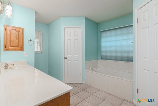 bathroom with a bath, tile patterned flooring, and vanity