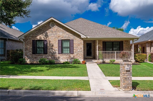 ranch-style house featuring a front yard and covered porch