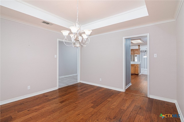 spare room with dark hardwood / wood-style floors, crown molding, and a notable chandelier