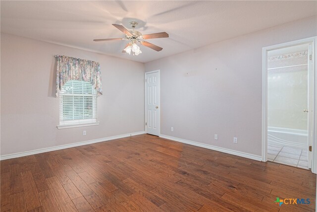 unfurnished room with dark wood-type flooring and ceiling fan