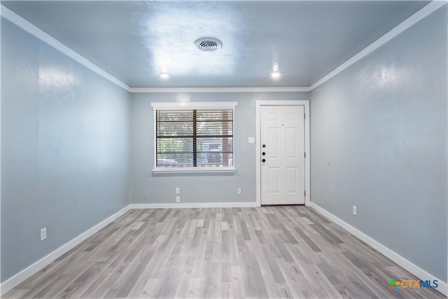 unfurnished room featuring crown molding and light wood-type flooring