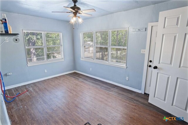 unfurnished room with ceiling fan and dark hardwood / wood-style flooring