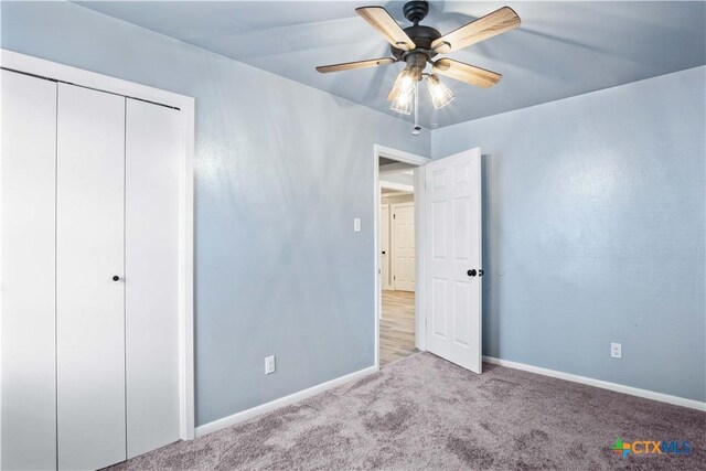 unfurnished bedroom featuring light colored carpet, a closet, and ceiling fan