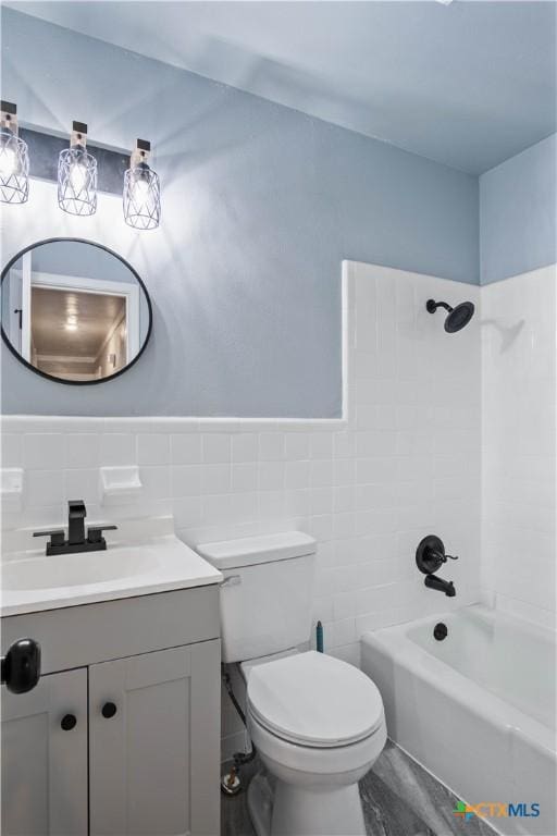 full bathroom featuring vanity, tile walls, toilet, and tiled shower / bath