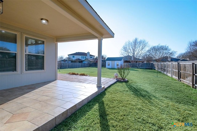 view of yard featuring a fenced backyard, a residential view, a patio, and an outdoor structure