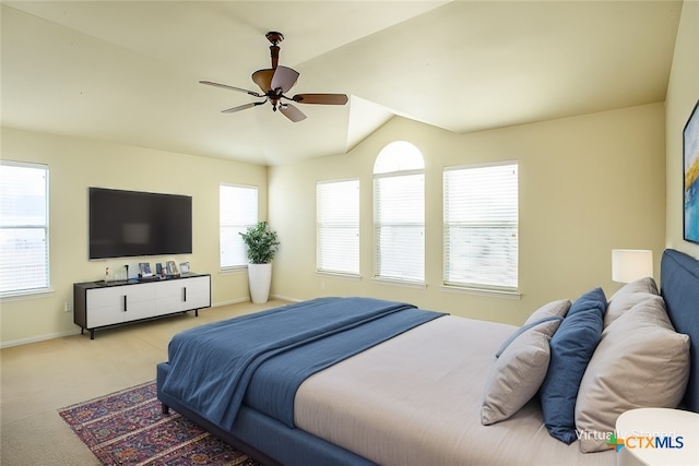 bedroom with light carpet, multiple windows, baseboards, and vaulted ceiling