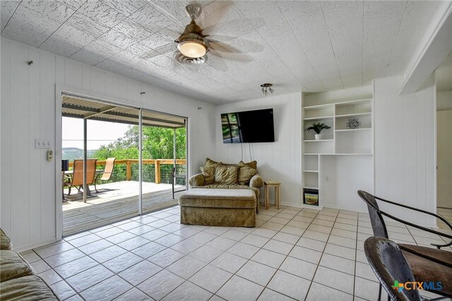 284 Lake Frst, Canyon Lake, TX 78133 - living room featuring light tile patterned floors, ceiling fan, wooden walls, and built in features