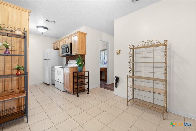 502 Geri Dr, Copperas Cove, TX 76522 - kitchen featuring white appliances, light brown cabinets, light countertops, a textured ceiling, and light tile patterned flooring