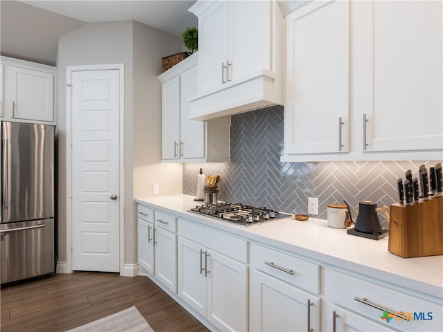 kitchen with premium range hood, dark hardwood / wood-style floors, decorative backsplash, white cabinetry, and stainless steel appliances