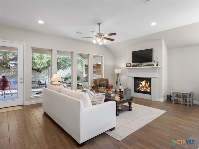 living room with dark hardwood / wood-style floors, ceiling fan, and vaulted ceiling