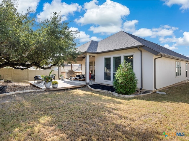 rear view of house featuring a lawn and a patio area