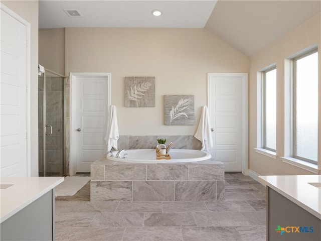 bathroom with vanity, vaulted ceiling, and independent shower and bath